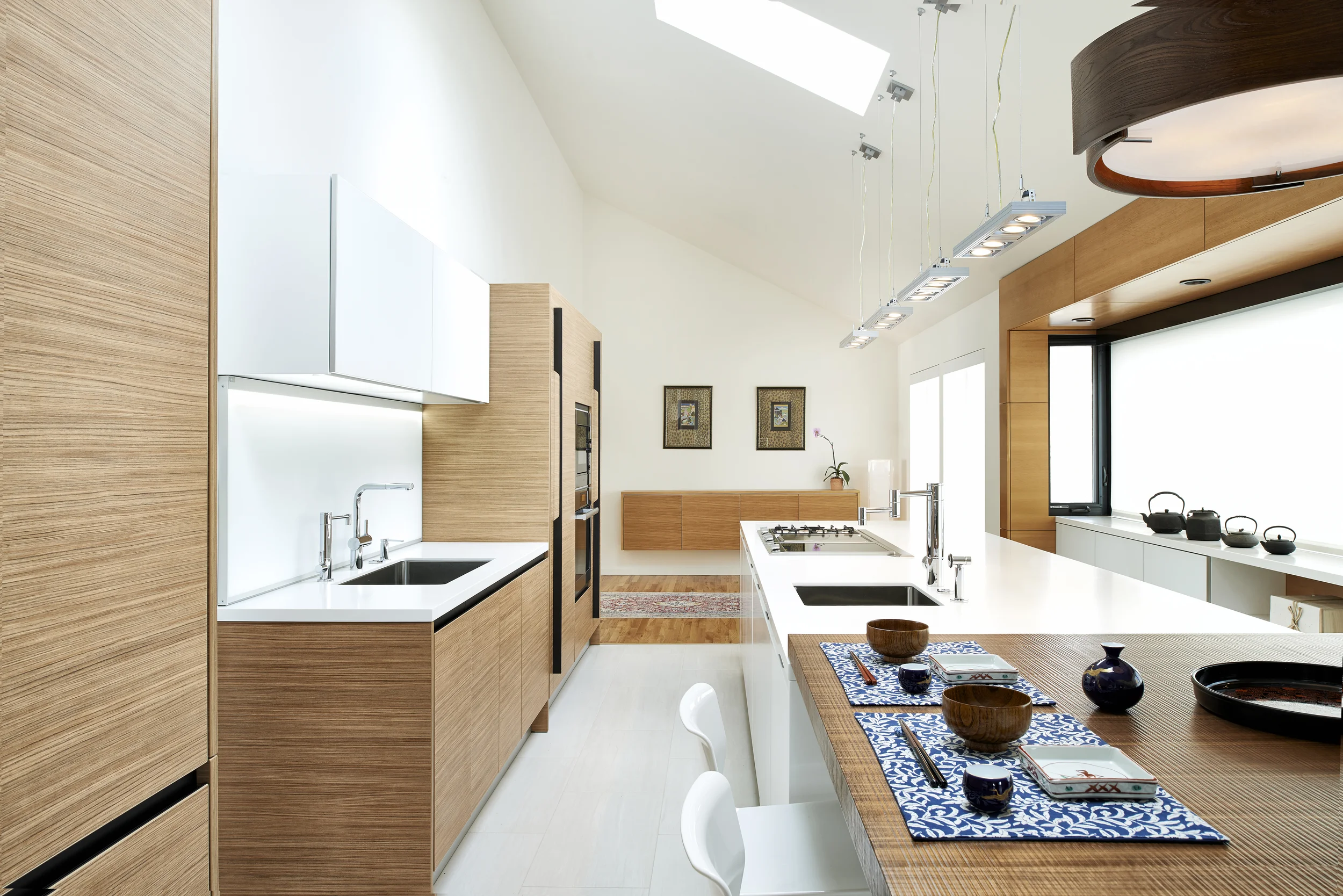 project details: white matt lacquer european textured melamine snow white krion tops matt glass back-splash veselbrand " stick " tall pulls Blum servo hardware / uppers vertical grain fir wall panels miele appliances