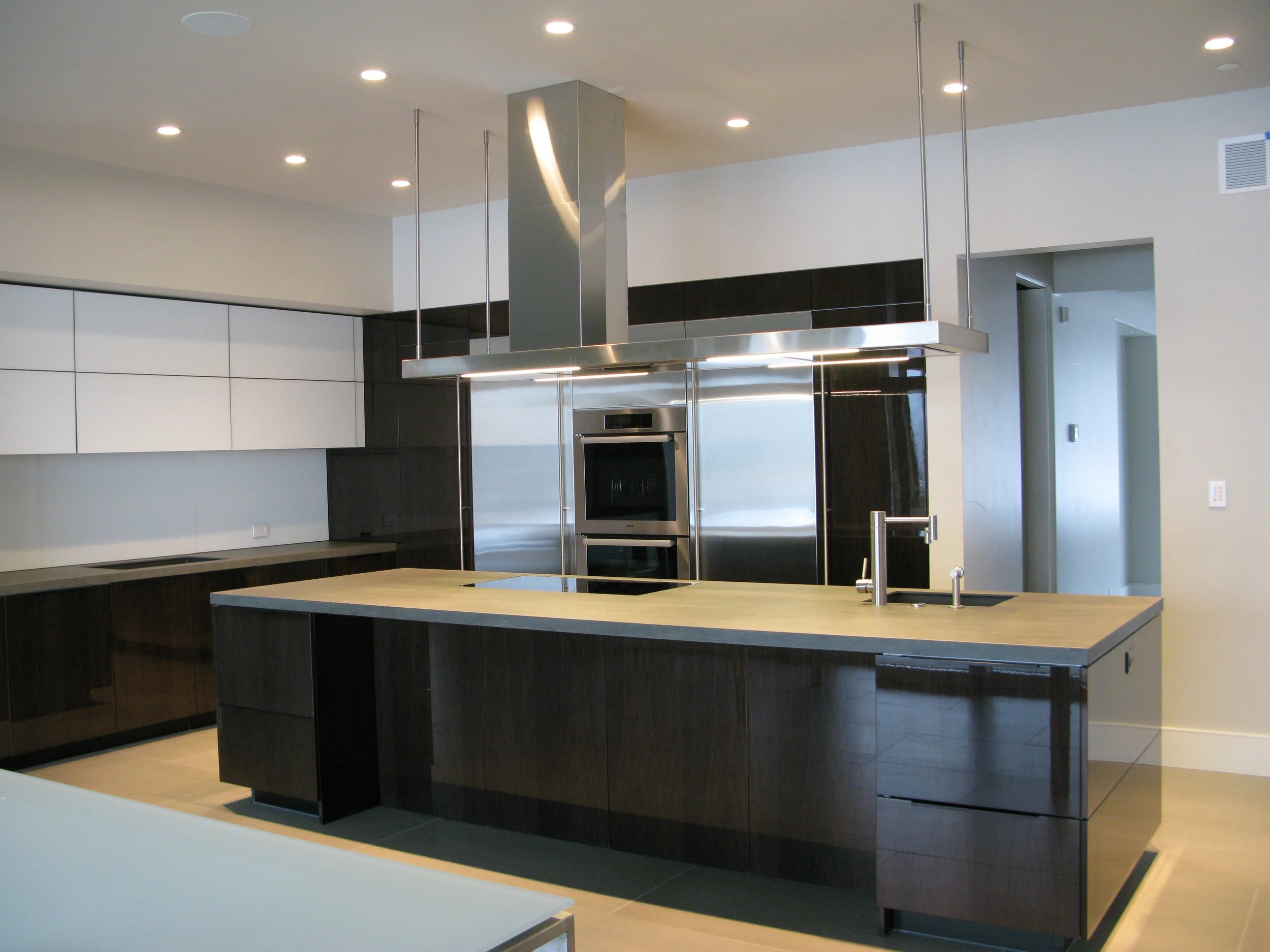 project details _______________________ high gloss walnut neolith countertops matt glass back-splash veselbrand europa air hood custom stainless fridge & freezer doors Blum servo hardware / uppers miele appliances