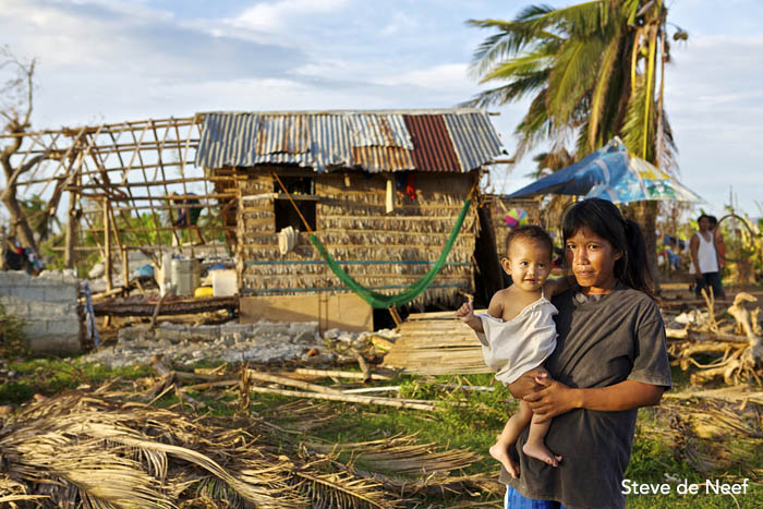 A local Madridejos women and her baby stand in front of her destroyed house after Typhoon Yolanda passed over the island.