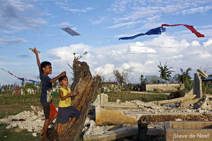 A pair of boys fly kites amid the ruins of Madridejos.