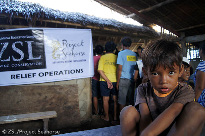 People wait patiently to receive emergency relief packs containing clean water, food, hygiene products, and essential medicine. Photo: Chai Apale/Project Seahorse