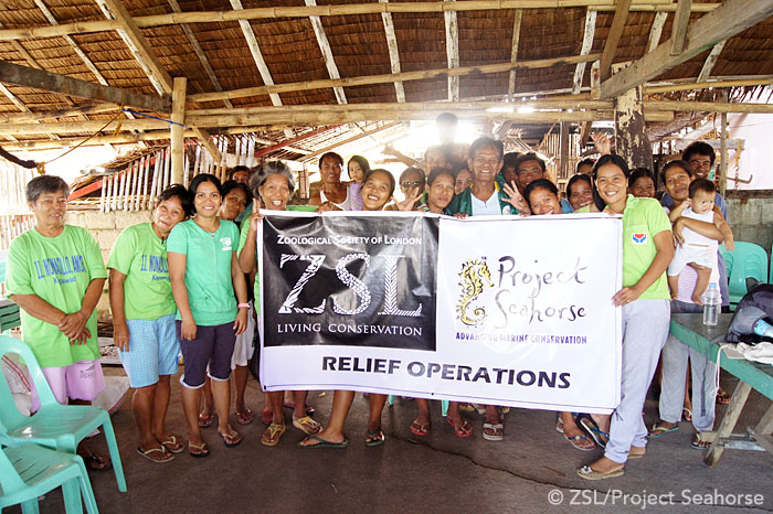 Members of a local Peoples' Organization (PO) pose for a team photo. PO's are an essential part of relief operations, often drawing their volunteers from the affected communities. Photo: Chai Apale/Project Seahorse