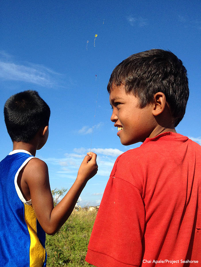 A sign of hope if there ever was one: A pair of boys fly homemade kits over what's left of their village. Photo: Chai Apale/Project Seahorse
