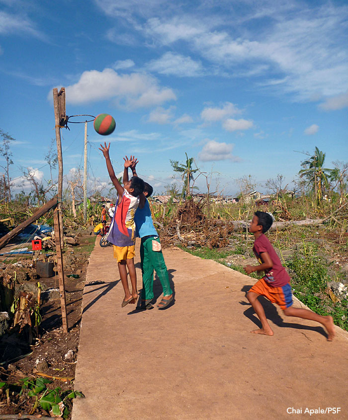 Signs of hope: Amid all of the destruction, life goes on. Boys play pickup basketball outside a village. Panay, Philippines. Photo: Chai Apale/Project Seahorse
