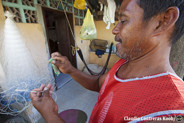 A fisher mends his net.