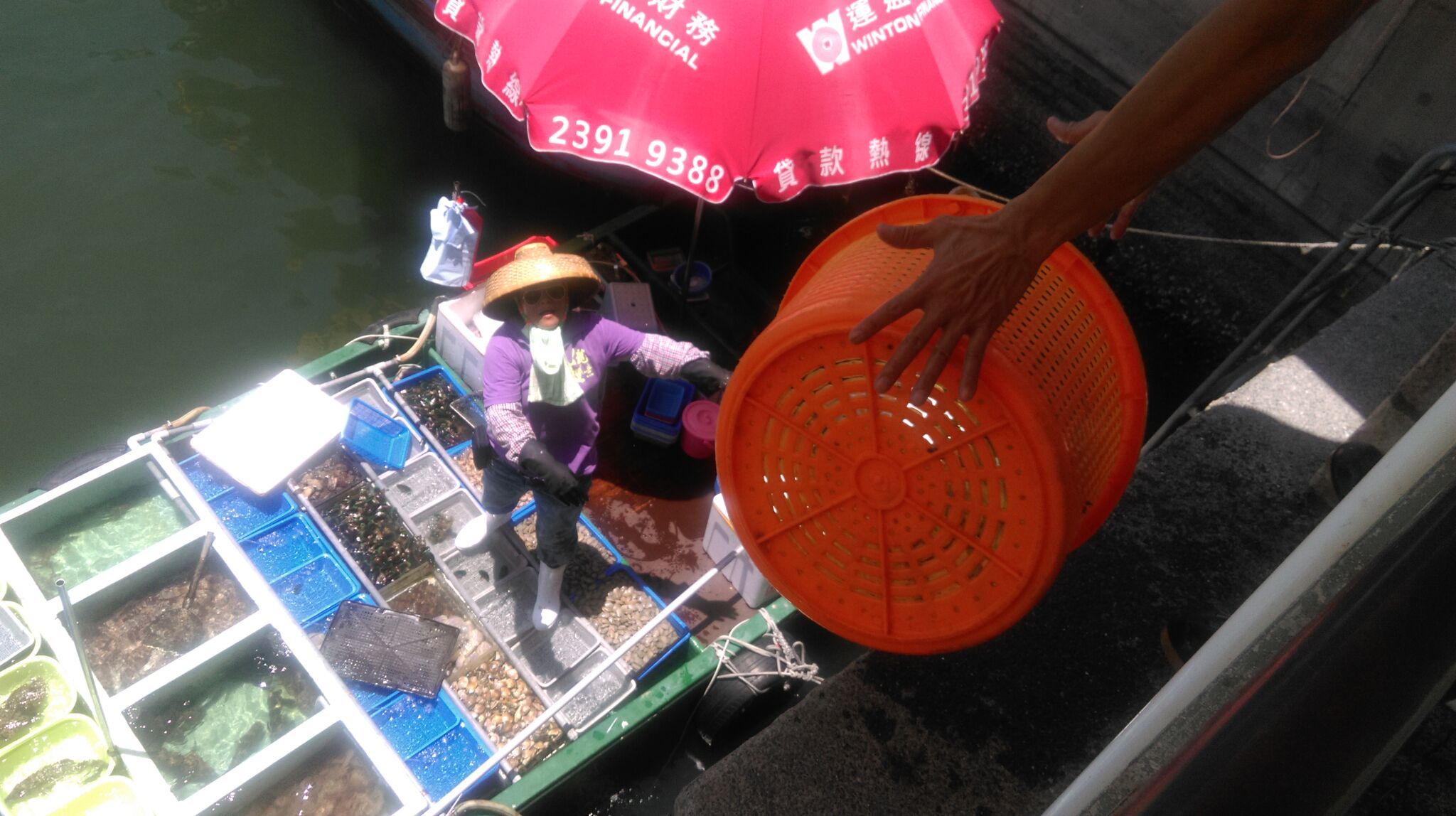 This is Sai Kung, a fishing/recreational port in Hong Kong, where trading seafood is done slightly differently - people standing on the pier stick out a net or a basket to the fishers on the boat and exchange seafood & money. TC Kuo/Project Seahorse