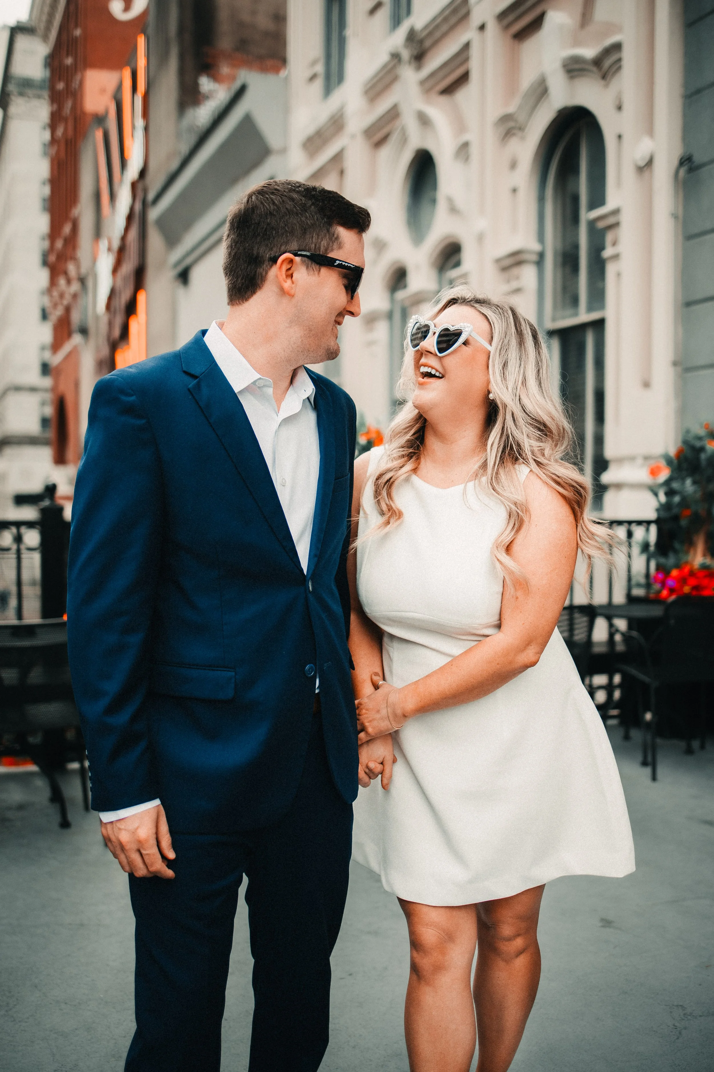 Caitlin and Collin walk hand in hand on the balcony at Captain Foxheart’s Bad News Bar in Houston, Texas during their engagement session.