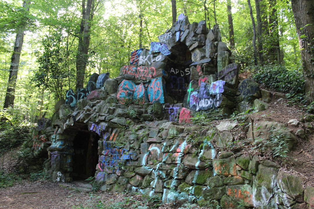 The state of Georgia granted this land to Ann Rich in 1821 after the Native Americans were forcibly removed from it. In 1901, La Societe Catholique Religieuse purchased a 100-acre tract of land as a retreat for the students and faculty of St. Stanislaus College, which La Societe oversaw. The Jesuits of the College constructed a shrine to Saint Bernadette shortly after purchasing the property, along with a reflection pool. The shrine has a large central entrance with a smaller cavity to the left where a fireplace is still visible. Over the top, there is a niche that originally contained a statue of the Virgin Mary, though it is no longer there. This shrine is one of the many copies of the original in Lourdes, France. Almost all of St. Stanislaus’ campus burned in a massive fire in 1921. For a few years, La Societe attempted to raise funds to rebuild the college with no success. They sold the land, which now contains many historically and architecturally significant homes. At the same time in 1929, La Societe sold the tract of virgin forest containing the Grotto to private developers, and the property has been privately owned ever since. The threats to the Grotto are DEMOLITION BY NEGLECT and ACTIVE VANDALISM. The solution for the Grotto is conservation easements and public access. The Grotto needs visitors who are interested in its history and preservation to discourage vandalism. The surrounding timber also needs a management plan to ensure this old growth hardwood remains for future generations.