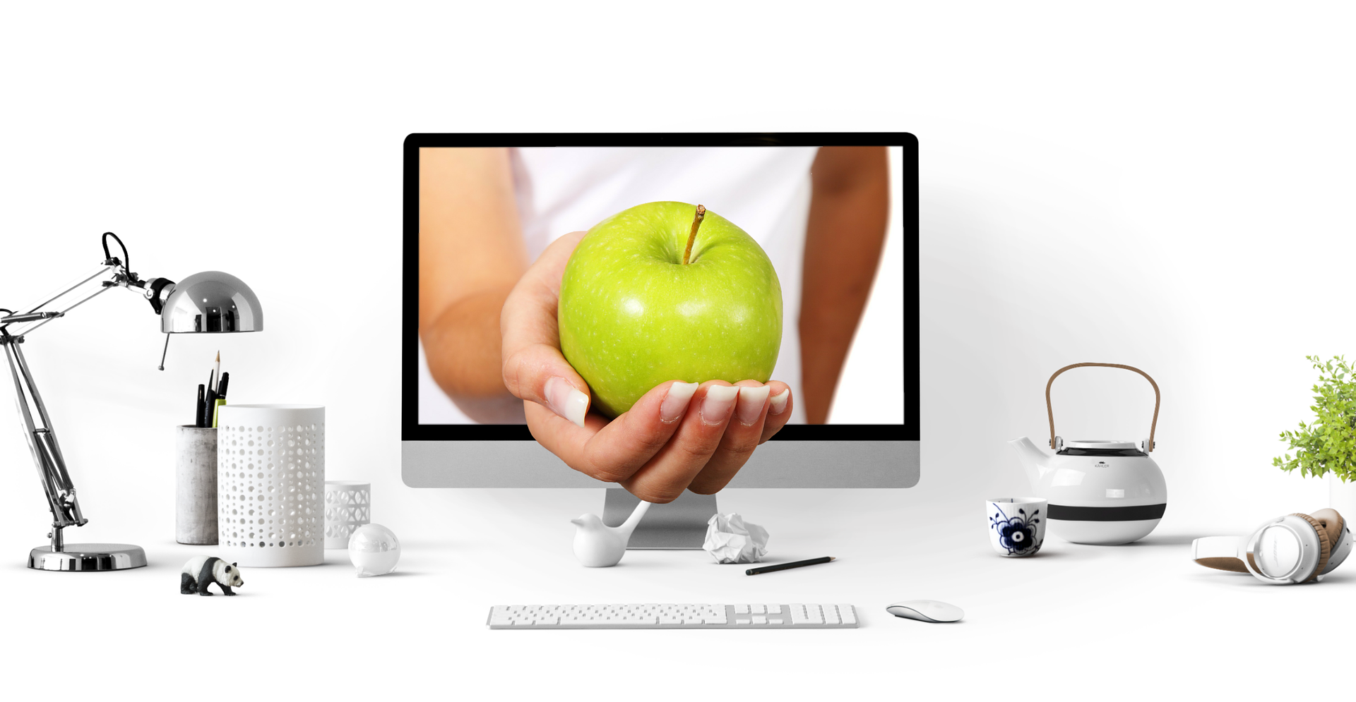 A computer monitor displaying a hand holding a green apple to indicate virtual nutrition appointment available online NZ wide