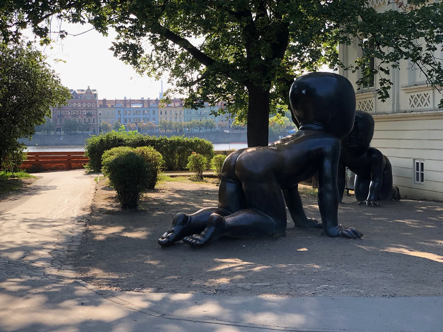 Giant babies with Vltava River and old town in the distance