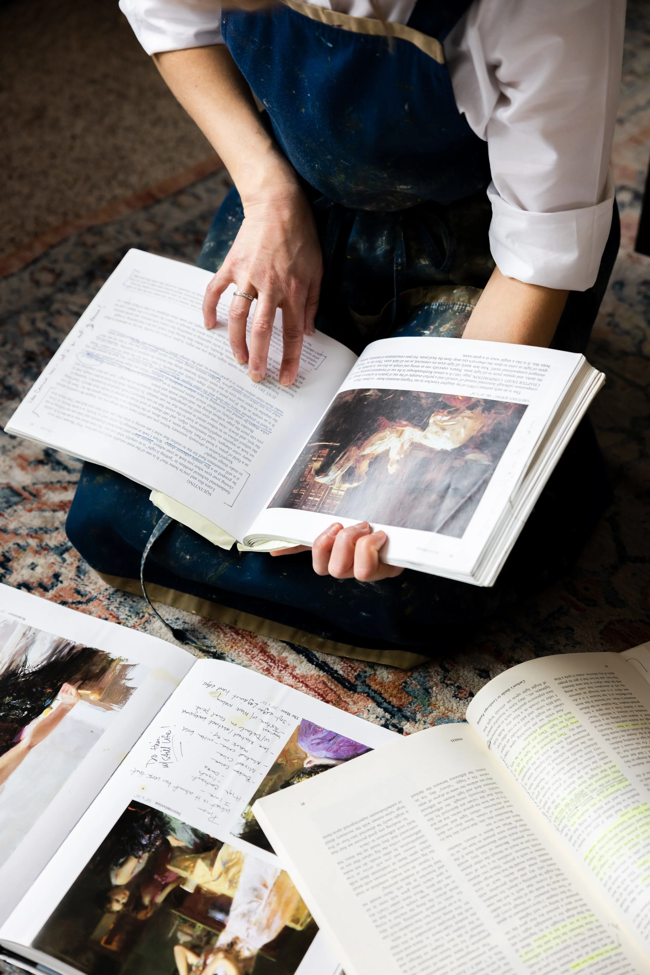 Idaho landscape artist Allie Zeyer browsing through her art book collection at her studio in Meridian, ID