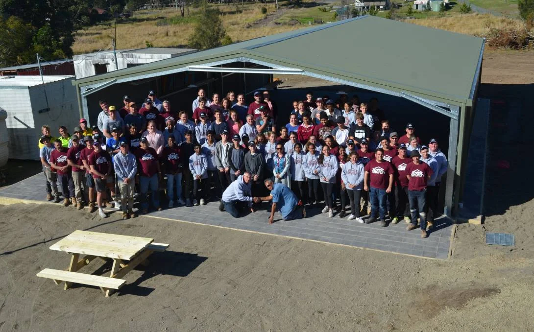 Redeemer Baptist School principal Jonathan Cannon shakes hands with Pastor Claude after laying the final stone.