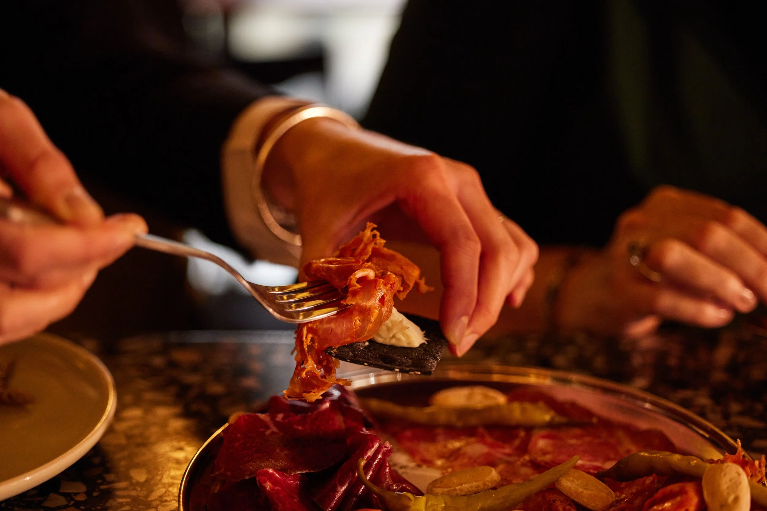 Hands spoon up food onto fork, at Potts Point Bar