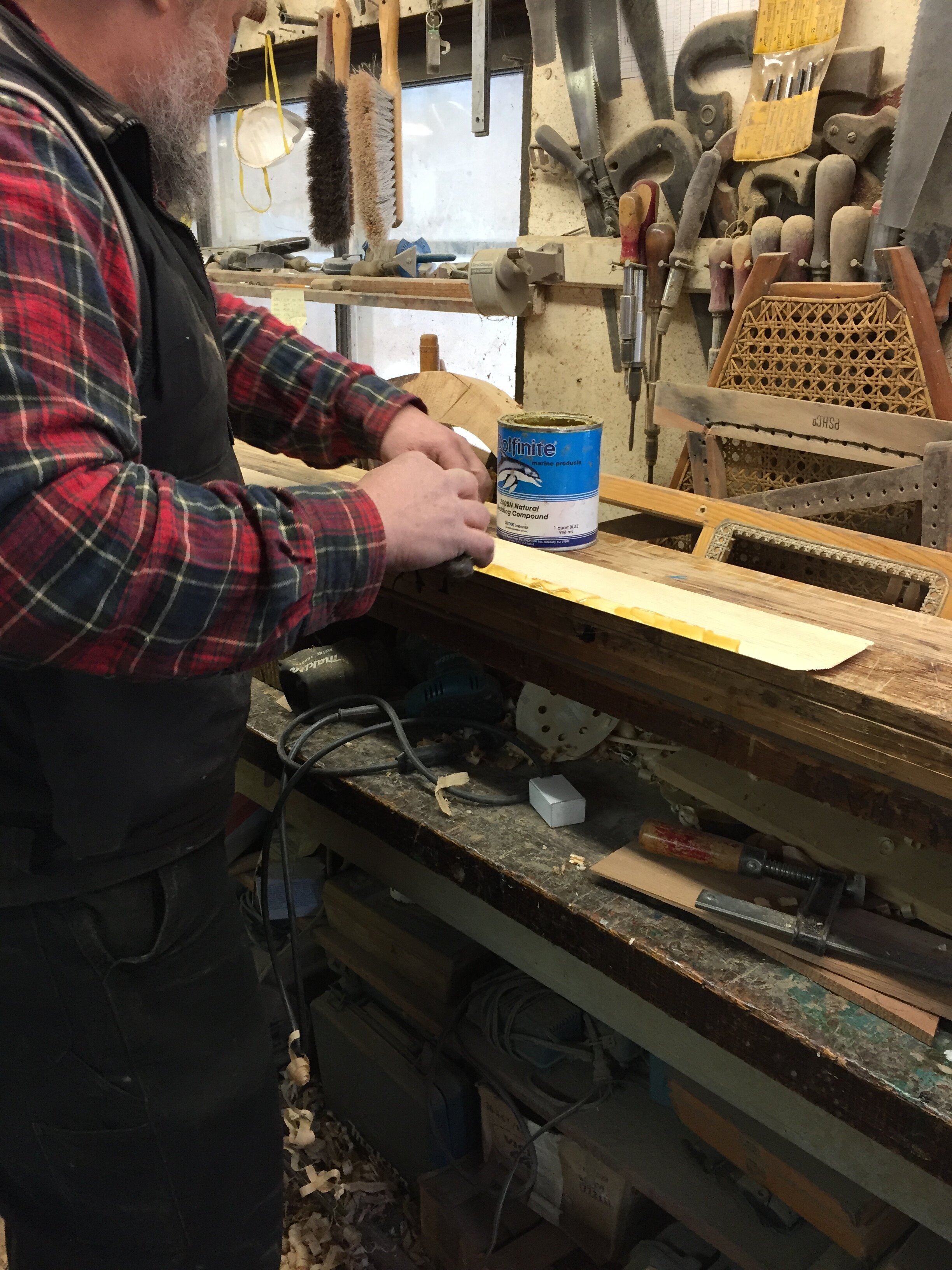 After tapering the the edges and fitting the planed plank, Chris is applying thinned Dolphinite before installation.