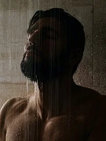 bearded man in the shower showing the use of Gentle Reign After shower body oil for men