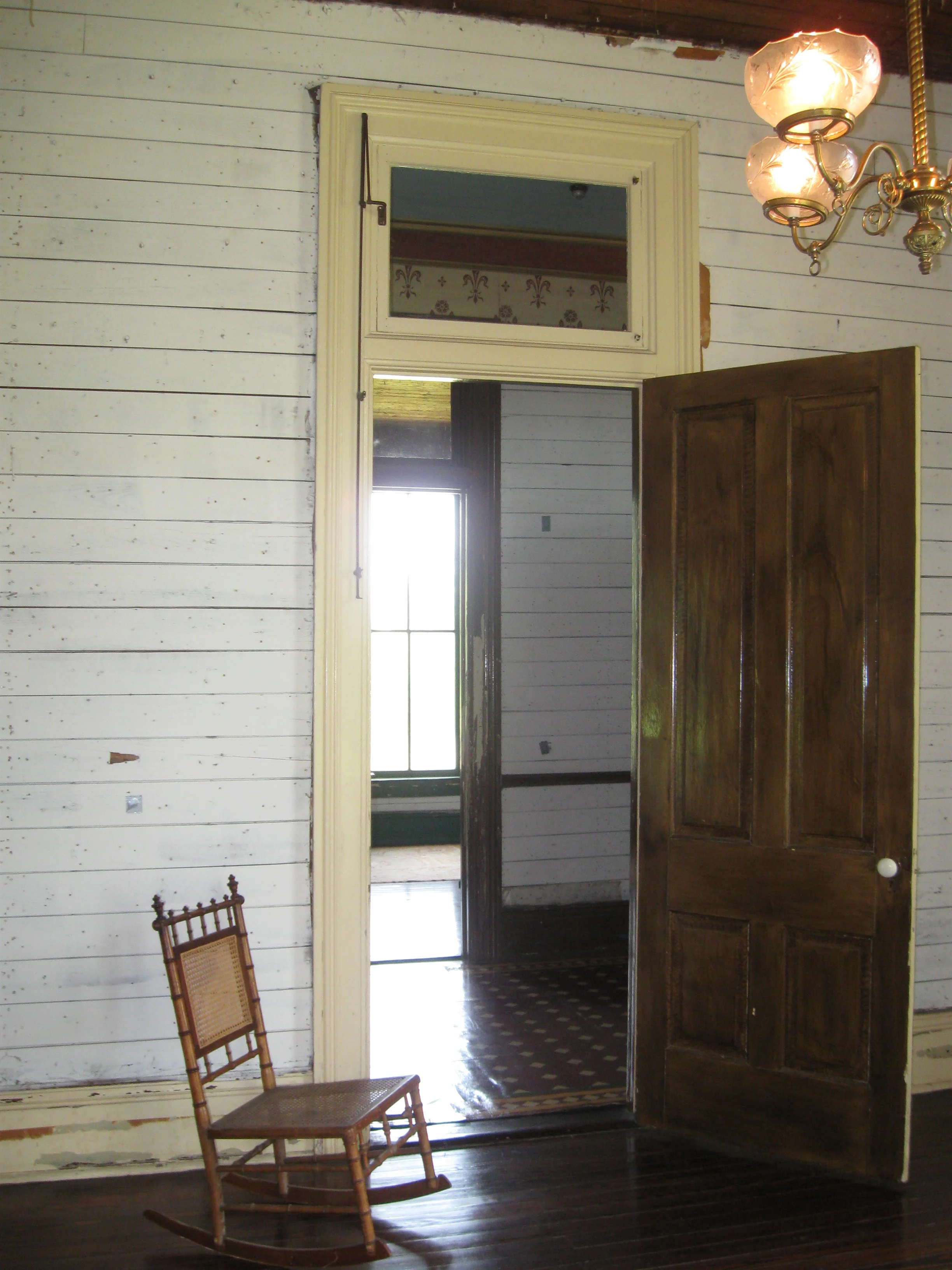 Pillot House door. The transom window above the door could be opened using the casement adjuster on the left. Note the height of the ceilings in relation to the rocking chair.