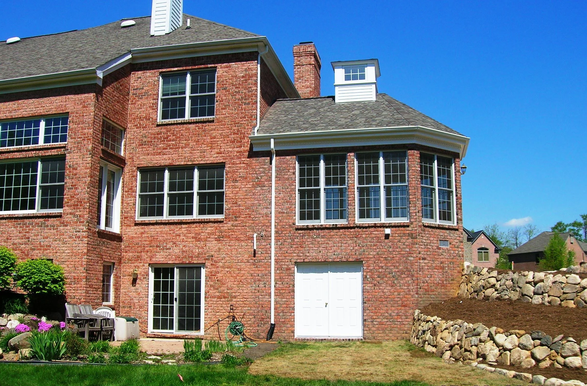 The exterior of the sunroom addition features a custom cupola for stargazing and large glass panels beneath a gable roof sunroom design, showcasing the unique architectural detail.