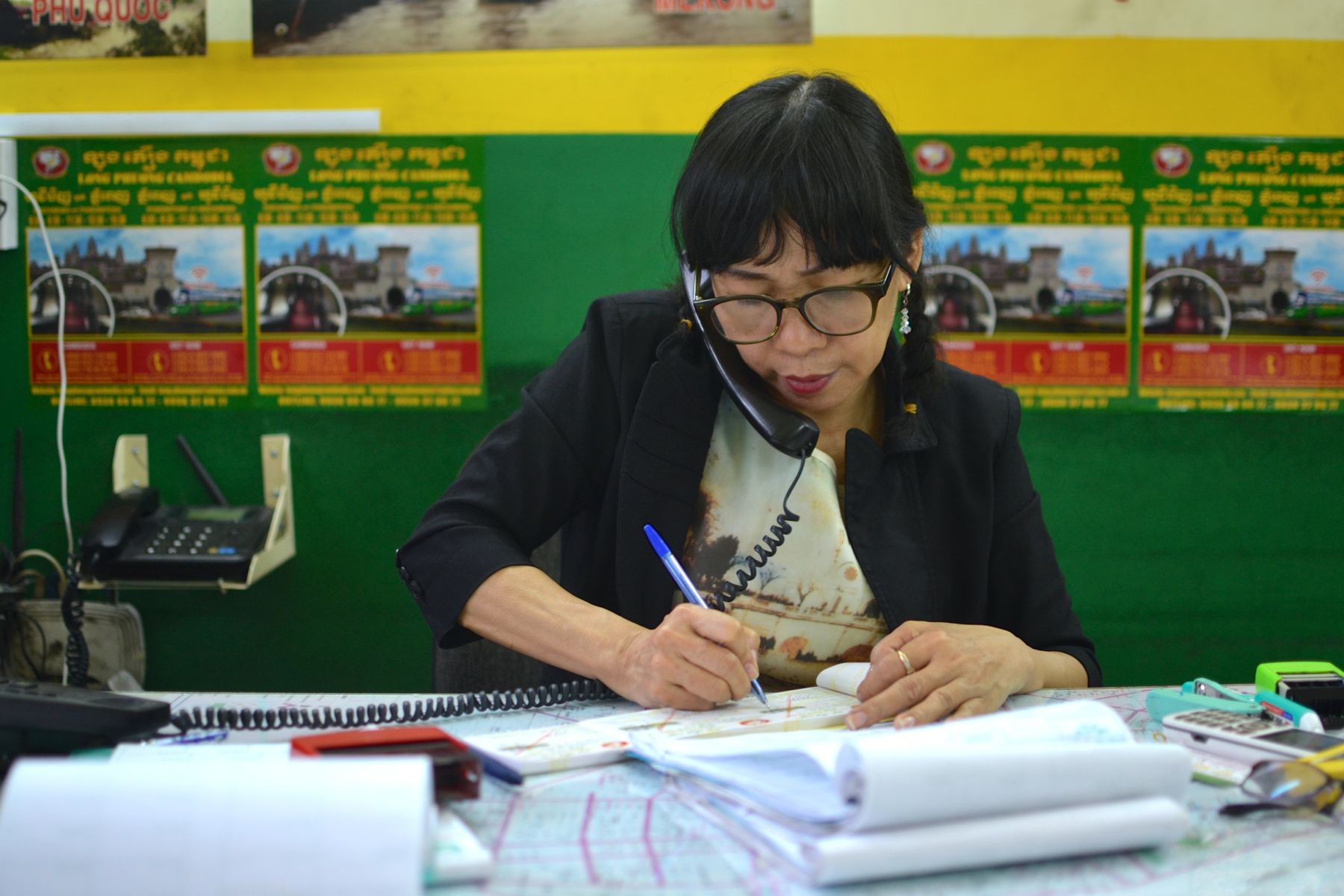 A Vietnamese travel agent - multitasking and just as busy as the ones back home