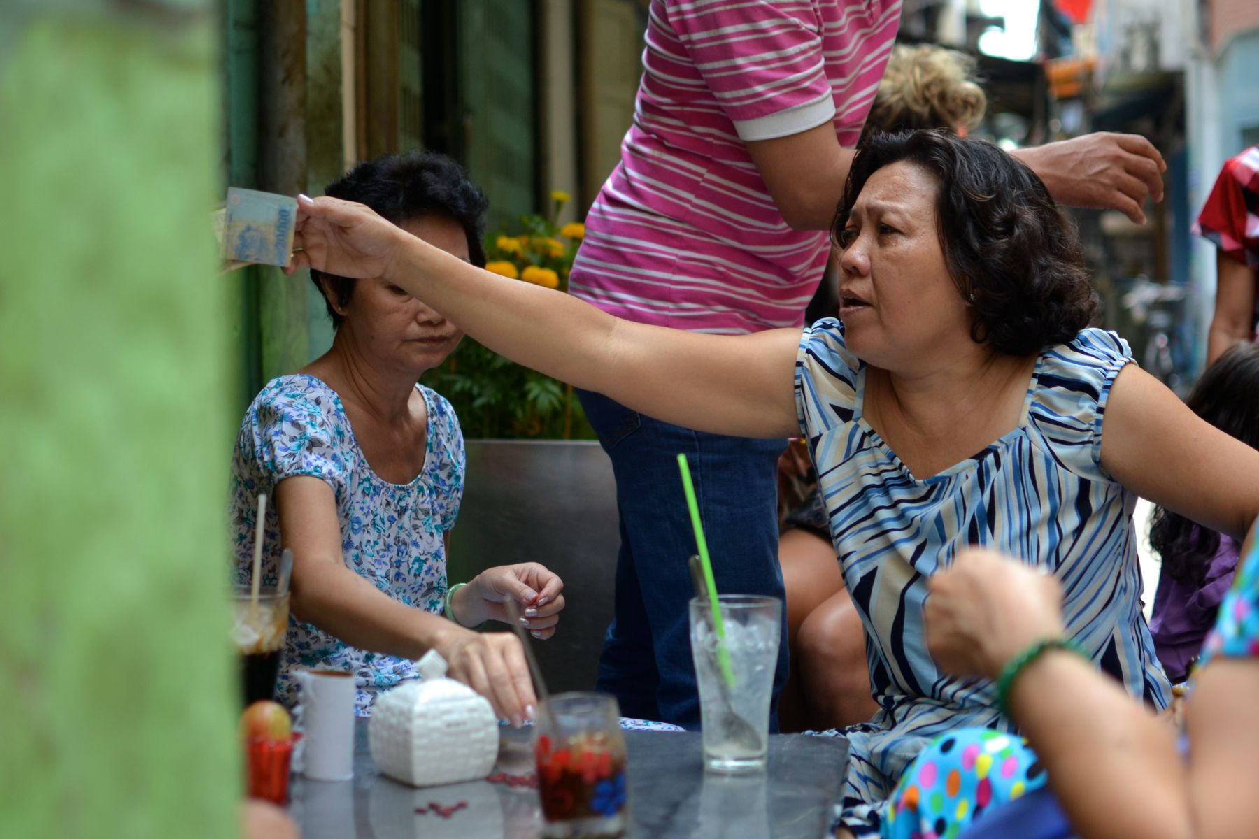Women drink morning coffee and socialize near their homes in an alley in Ho Chi Minh City