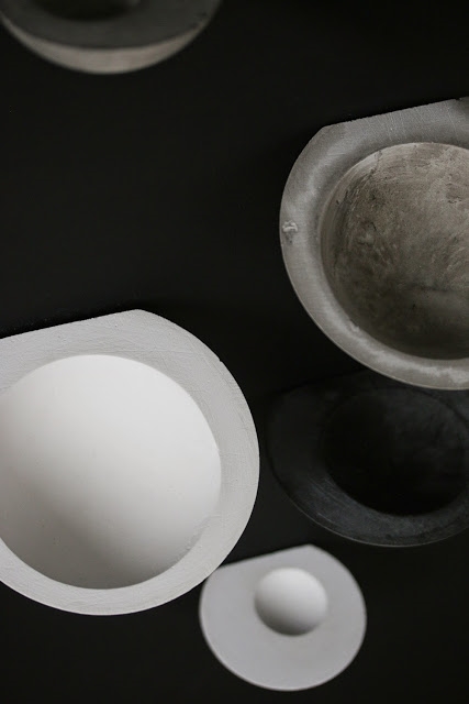 A close view showing gray, black, and white wall bowls with beautiful texture and asymmetry