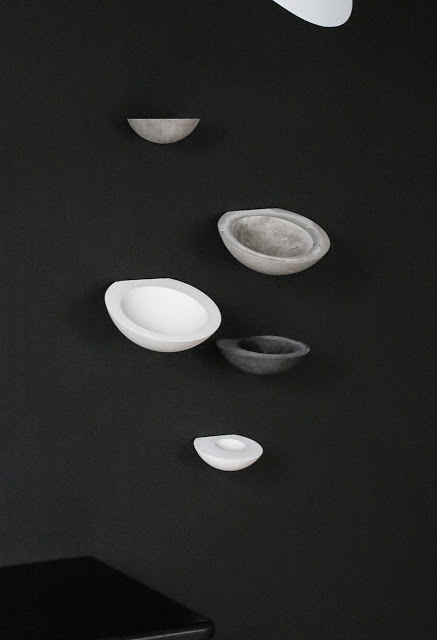 A side view showing some bowls with an angled back surface that lets the bowl opening bow down into the room. The mount is flush and sturdy against the wall. 