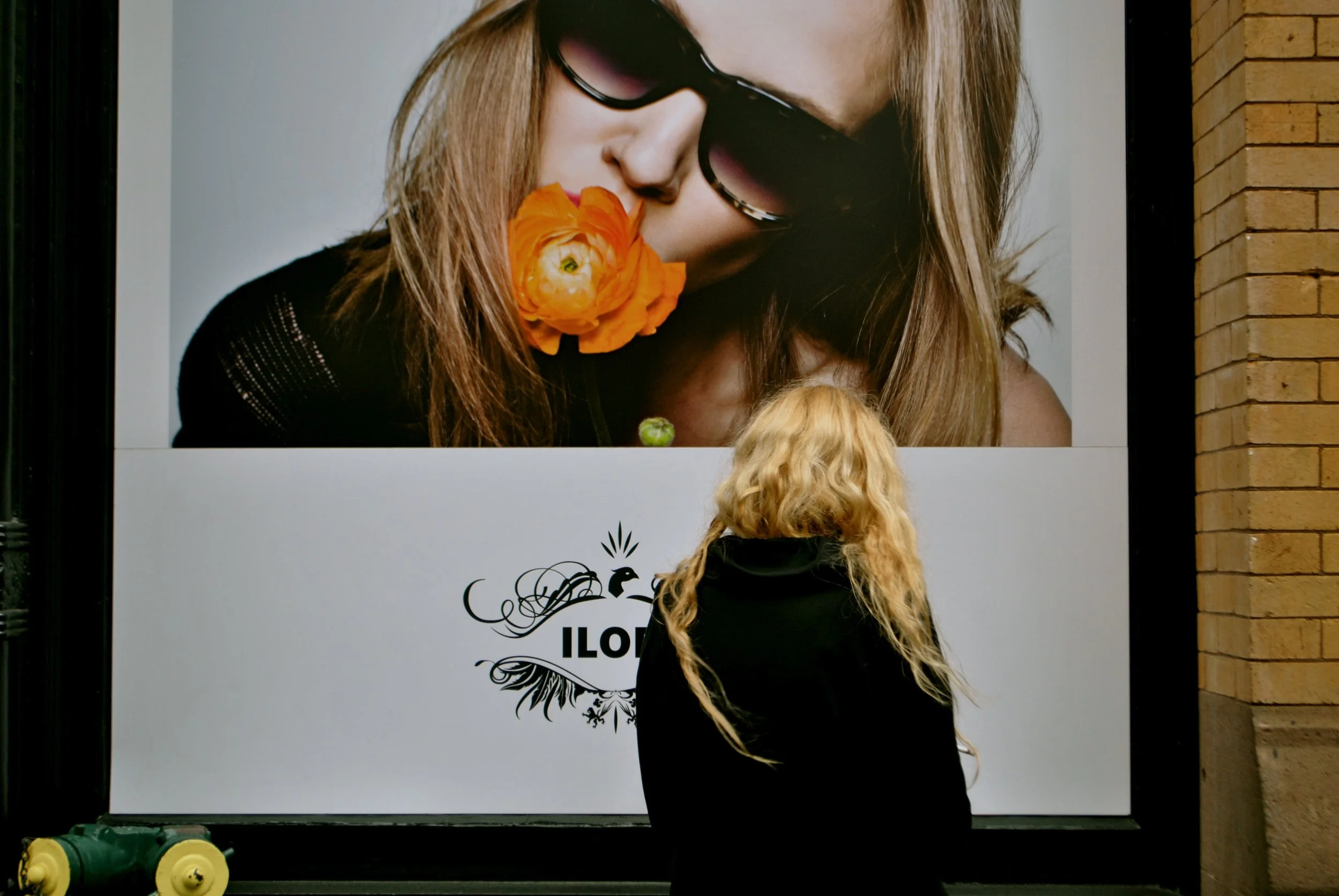  A passerby slows her stride and looks at a billboard.   “You seem like you know her?”     She takes a contemplative drag from her cigarette, exhales. “I do.”   