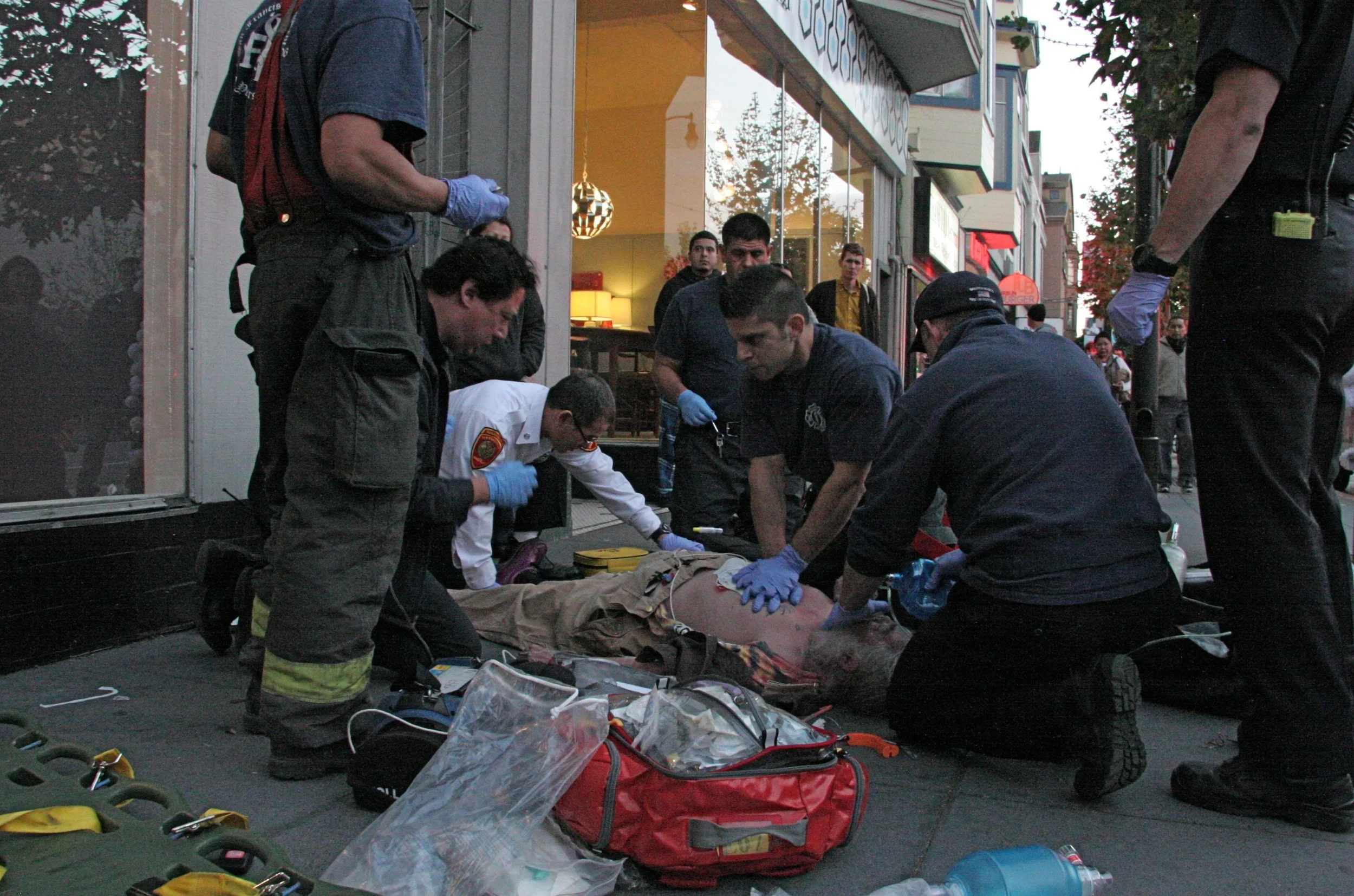  Firefighters work to revive a man that had an apparent heart attack. Witnesses saw the man have a syncope episode that collapsed him to the pavement,head thumping the solid surface.  