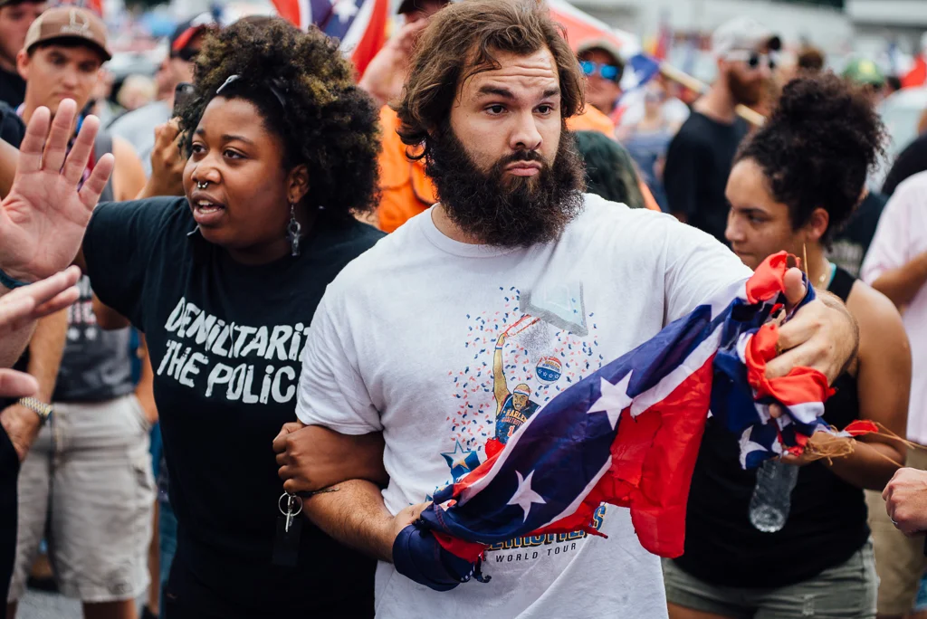 Elle Lucier and Tommy DiMassimo lock arms as they move through the crowd at the Confederate flag rally.