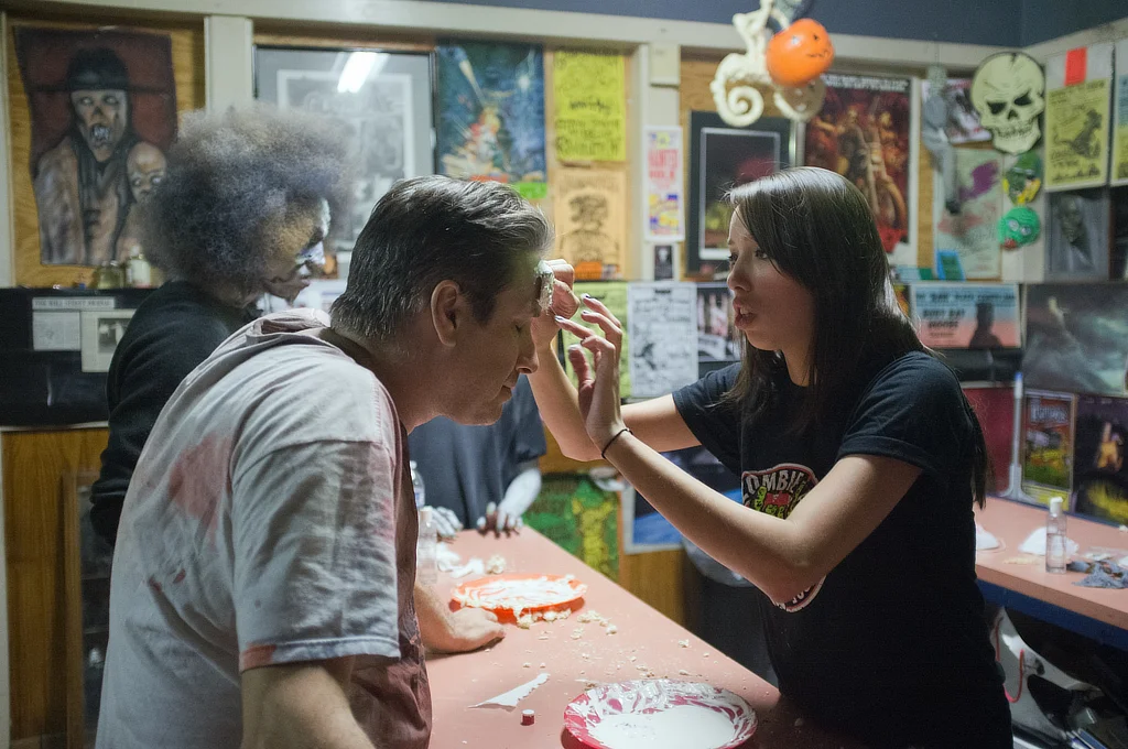 A woman applies makeup to a man at the Atlanta Zombie Apocalypse, a Halloween attraction that included a haunted house and paintball tournament. The attraction, once located in Conley, Georgia, has closed down because the property sold in 2015.