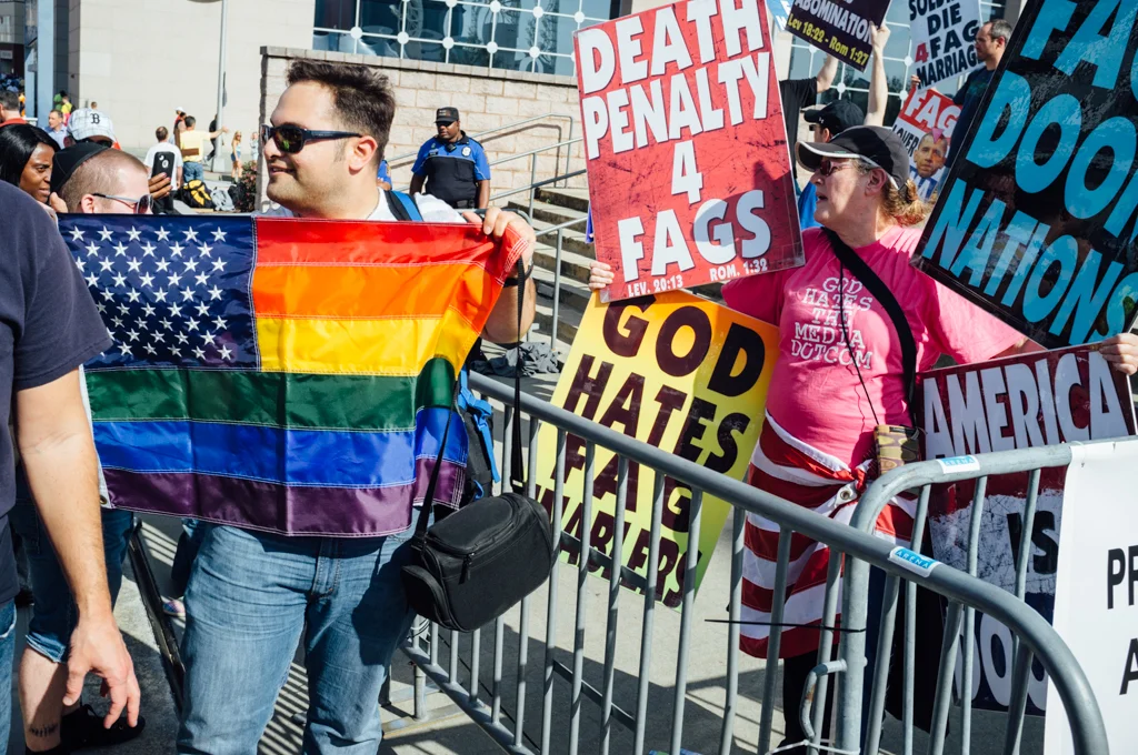 The Westboro Baptist Church protests outside the Georgia Dome in Atlanta during the NCAA Final Four tournament in April 2013. A man holds up a rainbow flag at a counter-protest.