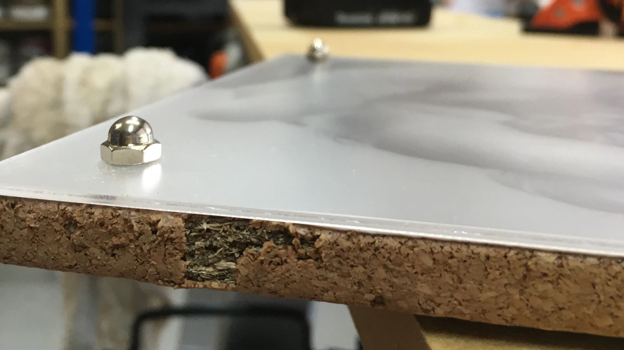7x10'' photograph sandwiched between non-glare acrylic glass and cork. Drilled through everything, then capped the screw with an acorn nut.