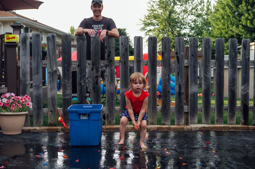 Brandon watches his daughter Chase toss a water balloon.