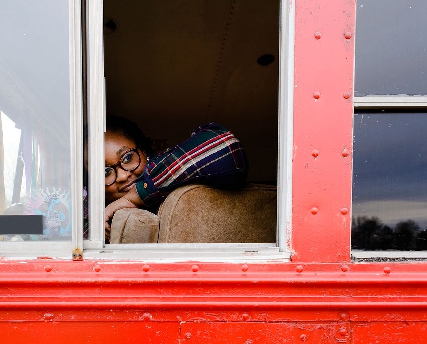 Candra looks out the school bus's driver side window.