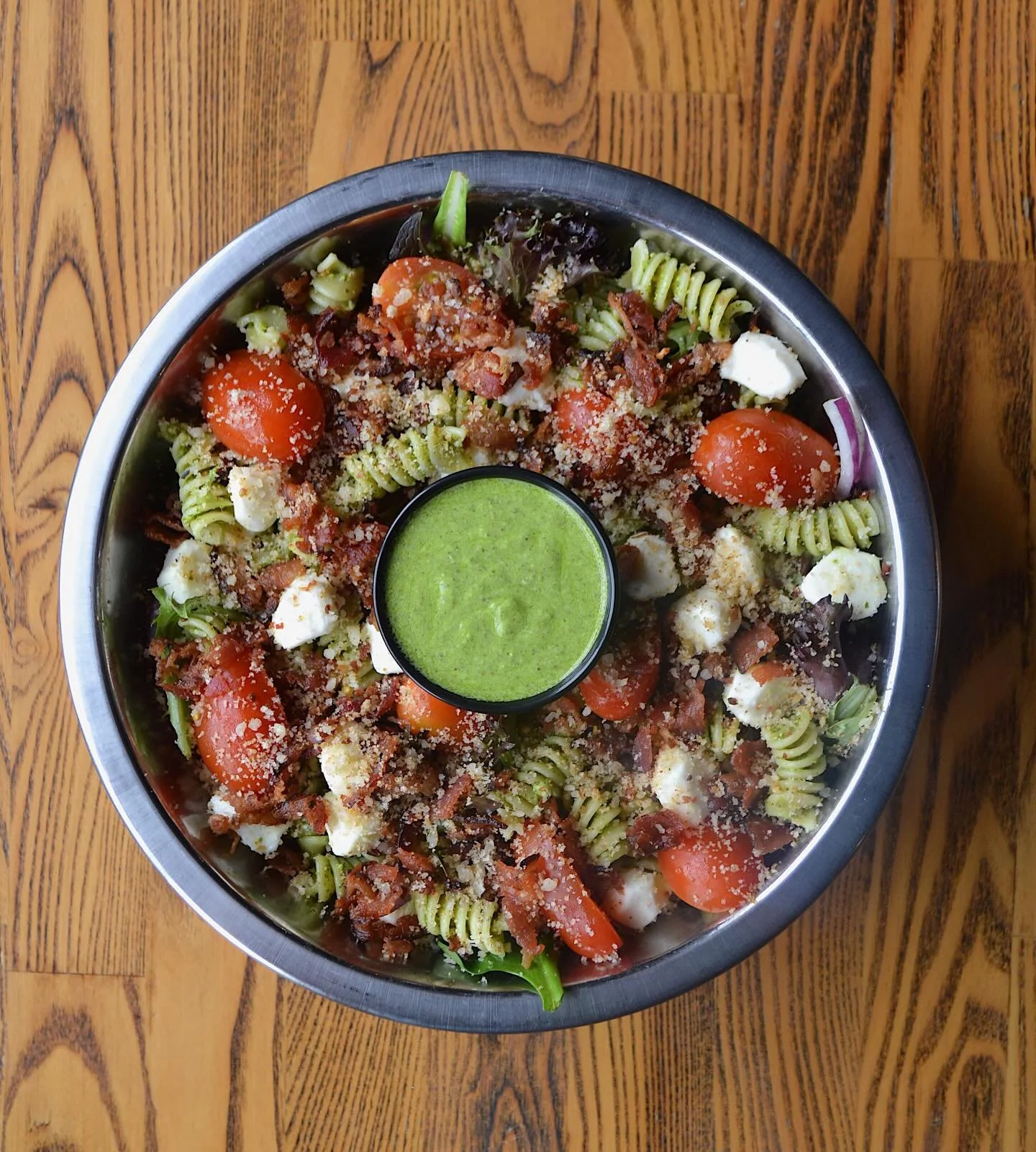 New salad, available today: Spring Pesto Pasta Salad! Fresh, flavorful, and light while still satisfying.
Spring mix, fusilli pasta, red onion, grape tomatoes, mozzarella pearls, smoked bacon, parmesan bread crumbs, and served with a creamy lemon bas