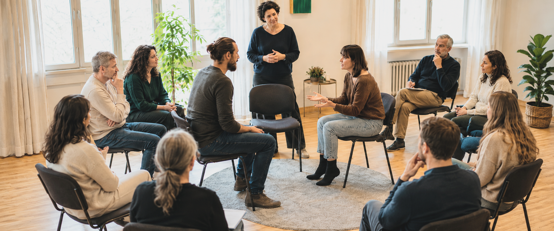 Gruppe von Menschen im Stuhlkreis in einem hellen Raum