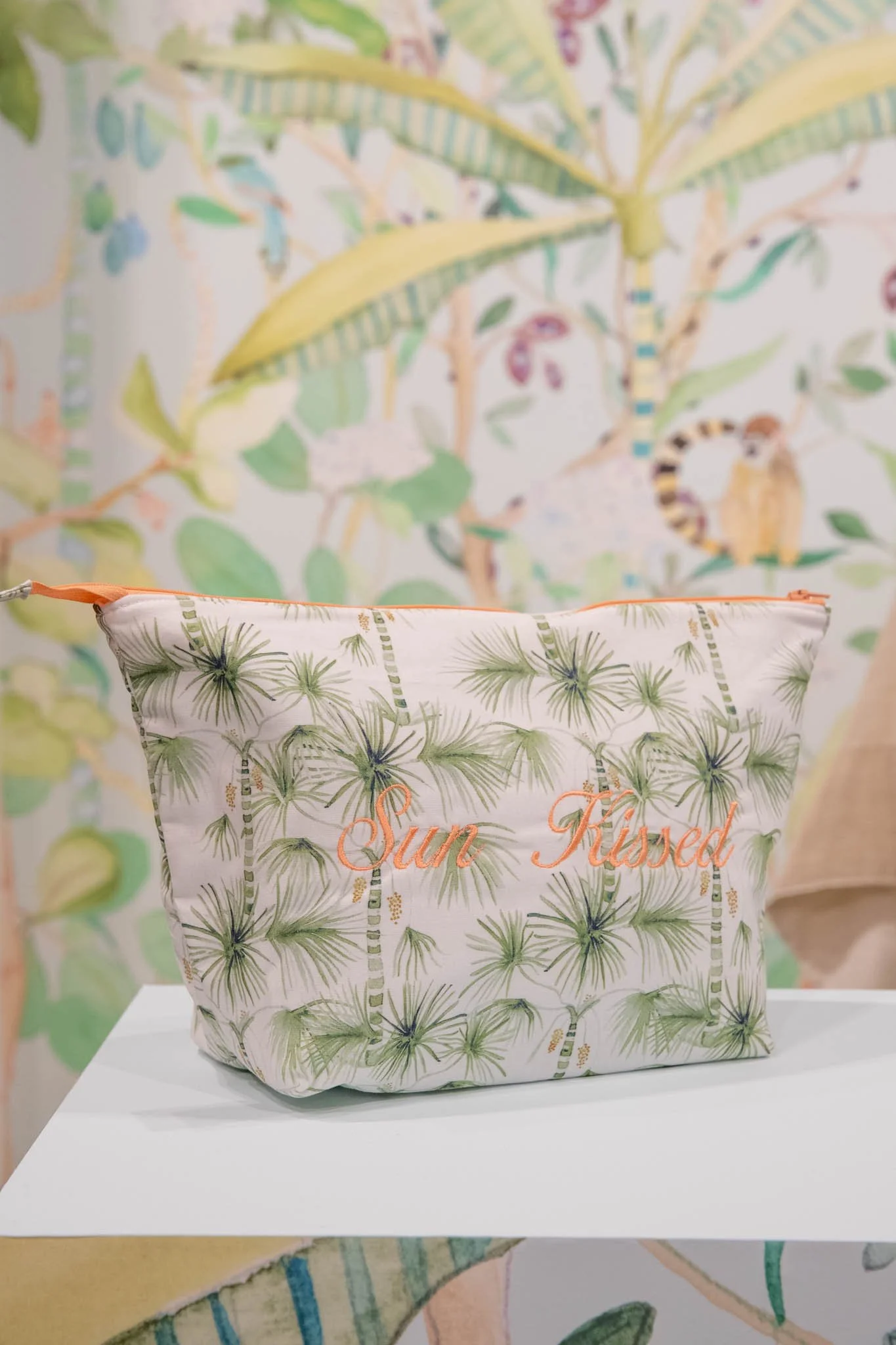 A cosmetic bag with green palm leaves print and customized embroidered at Bongénie Store Geneva