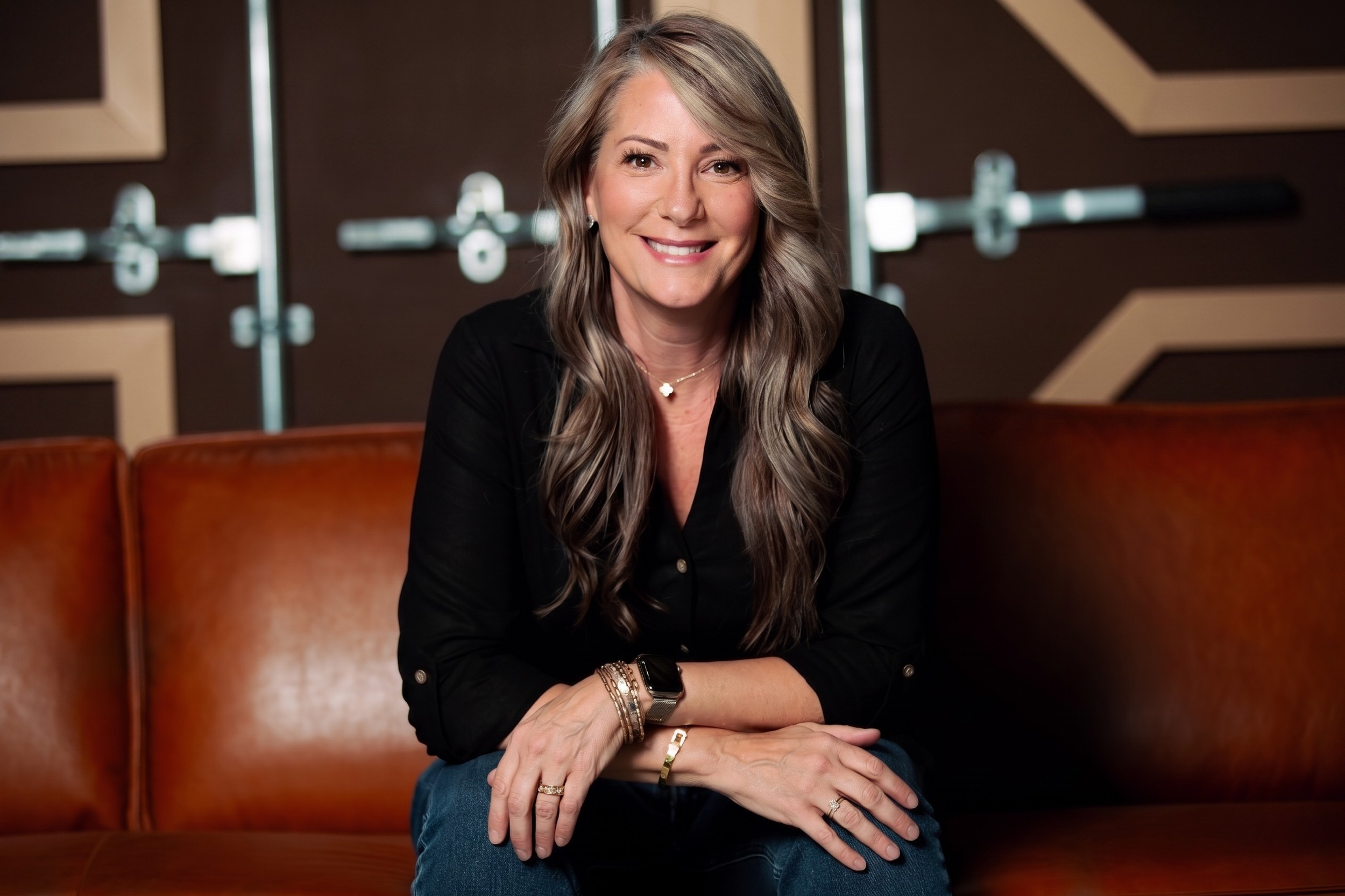 Lori, founder of Co. 1028, seated on a leather couch