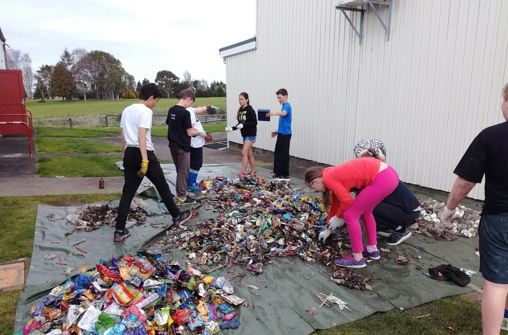 Eltham students sort the litter collected from under the school deck to identify recyclables.