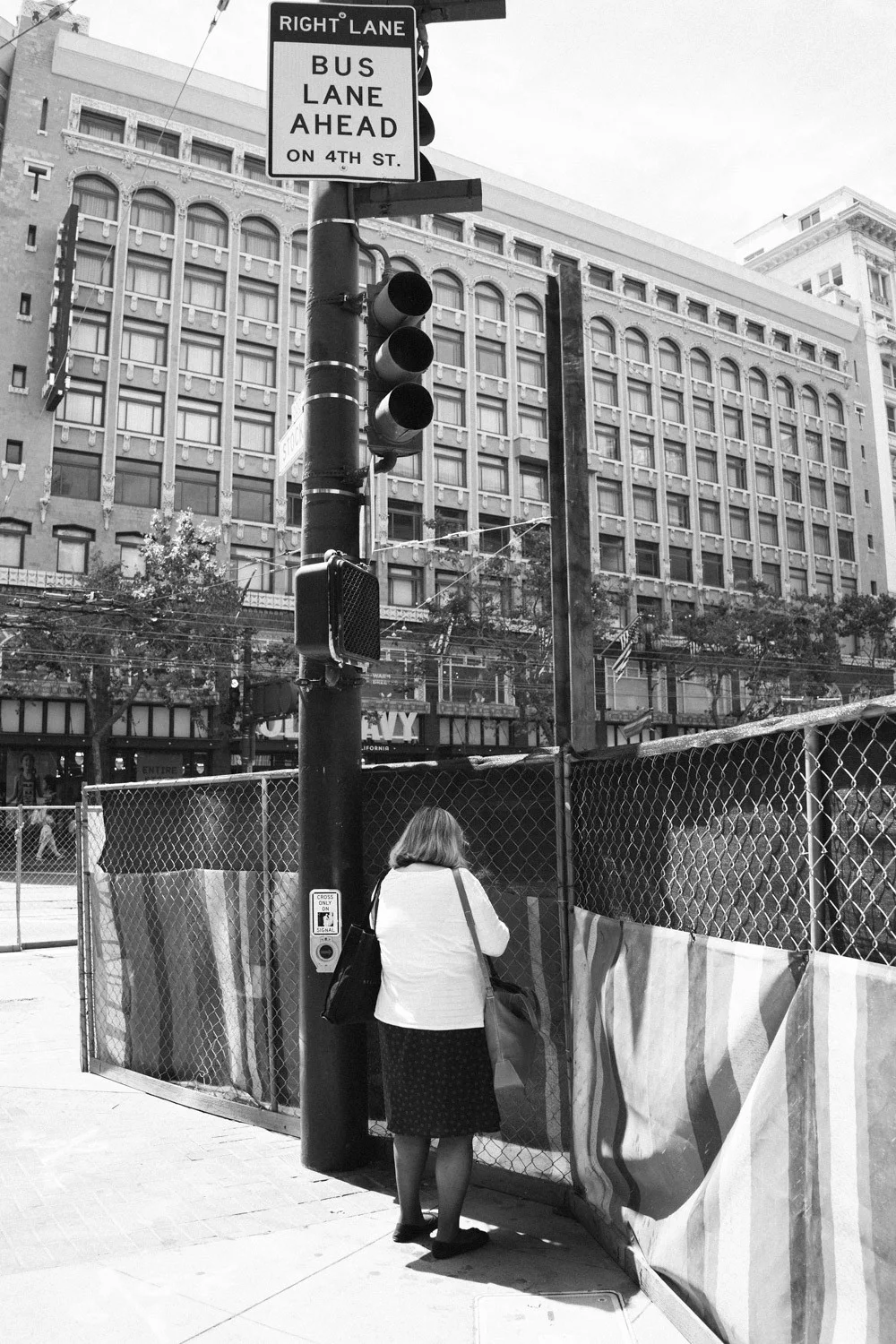 Woman standing on the street She stood there for a while. I think she is sorting out her bag or fixing something