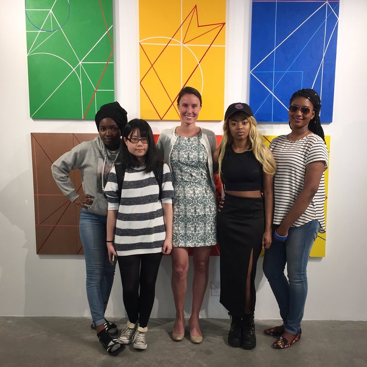 Our gallery director, Abigail Ogilvy, and AFH teens in front of their artwork