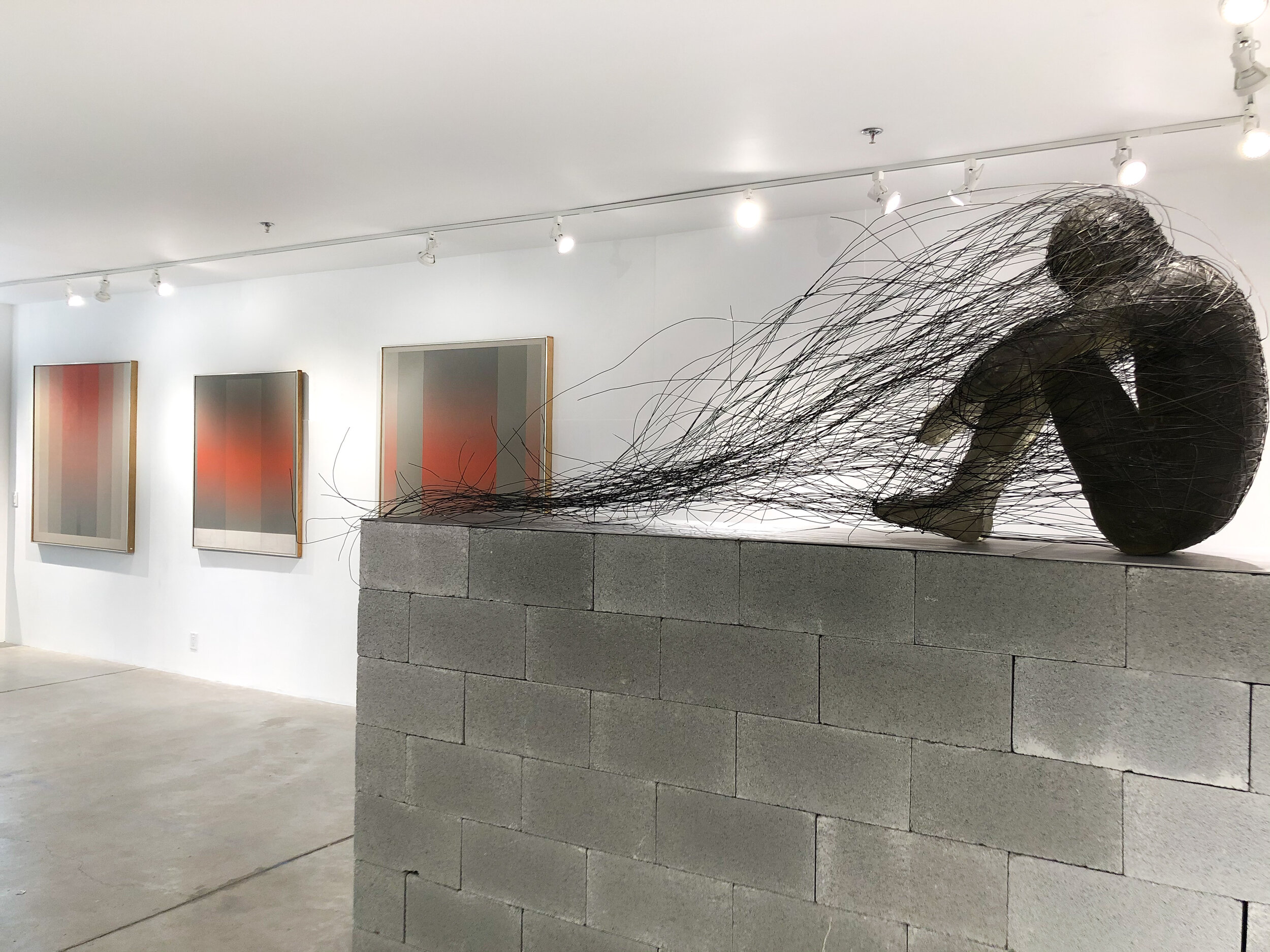 Installation view: John Day paintings (background, left); Nathaniel Price sculpture (foreground, right)