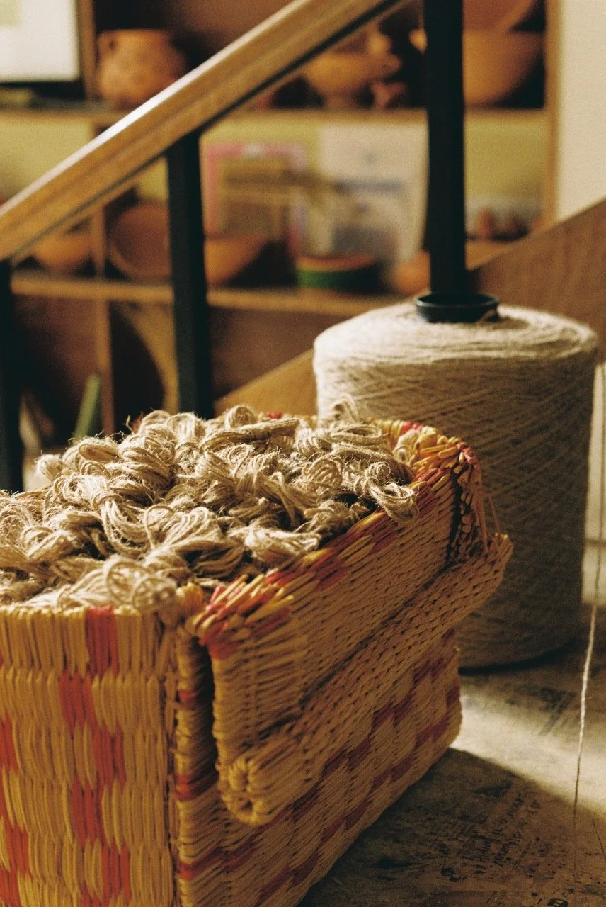 Close-up of a woven basket containing leftover thread from our loom finishes. We