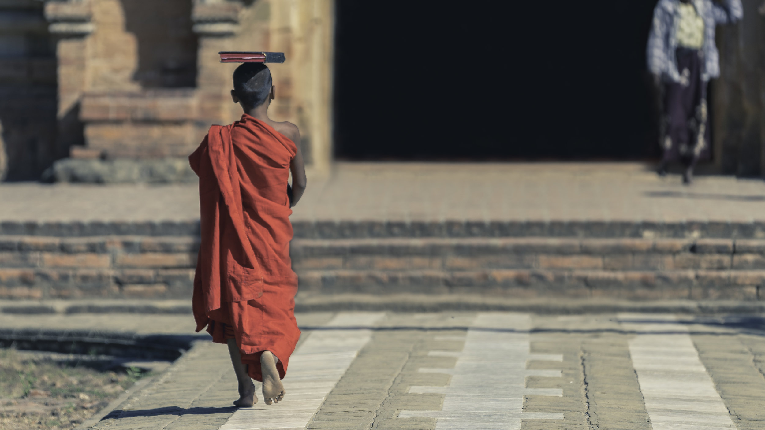 Young monk heading back to temple. Sights like these are common in the most areas of Myanmar. It is a tradition to send young boys to become monks for some period of time at a local temple.