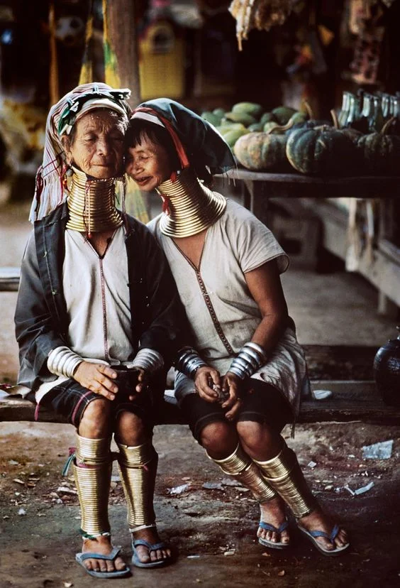 Padaung People The Padaung people mainly live in Kayah and Shan state, but few have travelled to Inle to start new lives. They are known for wearing long brass rings around their necks as a sign of beauty. These rings are a single piece of brass woven and coiled around their neck. Young girls early as the age of 5 wear these rings around their necks. Image by Steve McCurry 