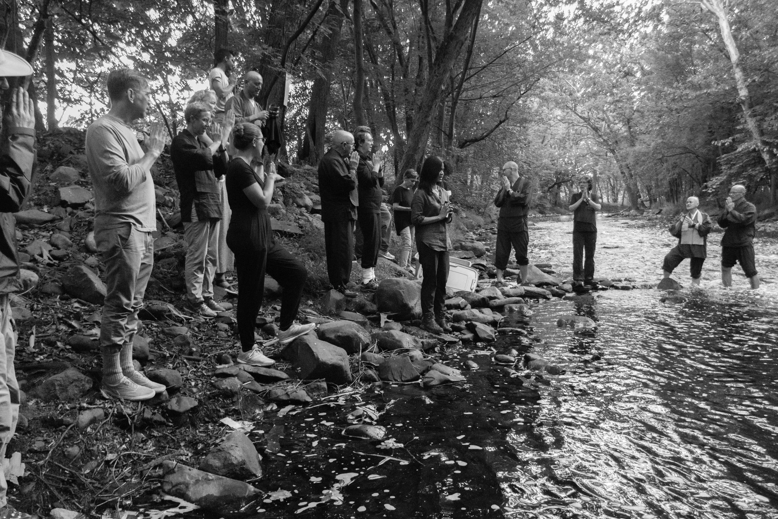 Members of Village Zendo stand along a river bank during the Obon ceremony honoring people who passed away.