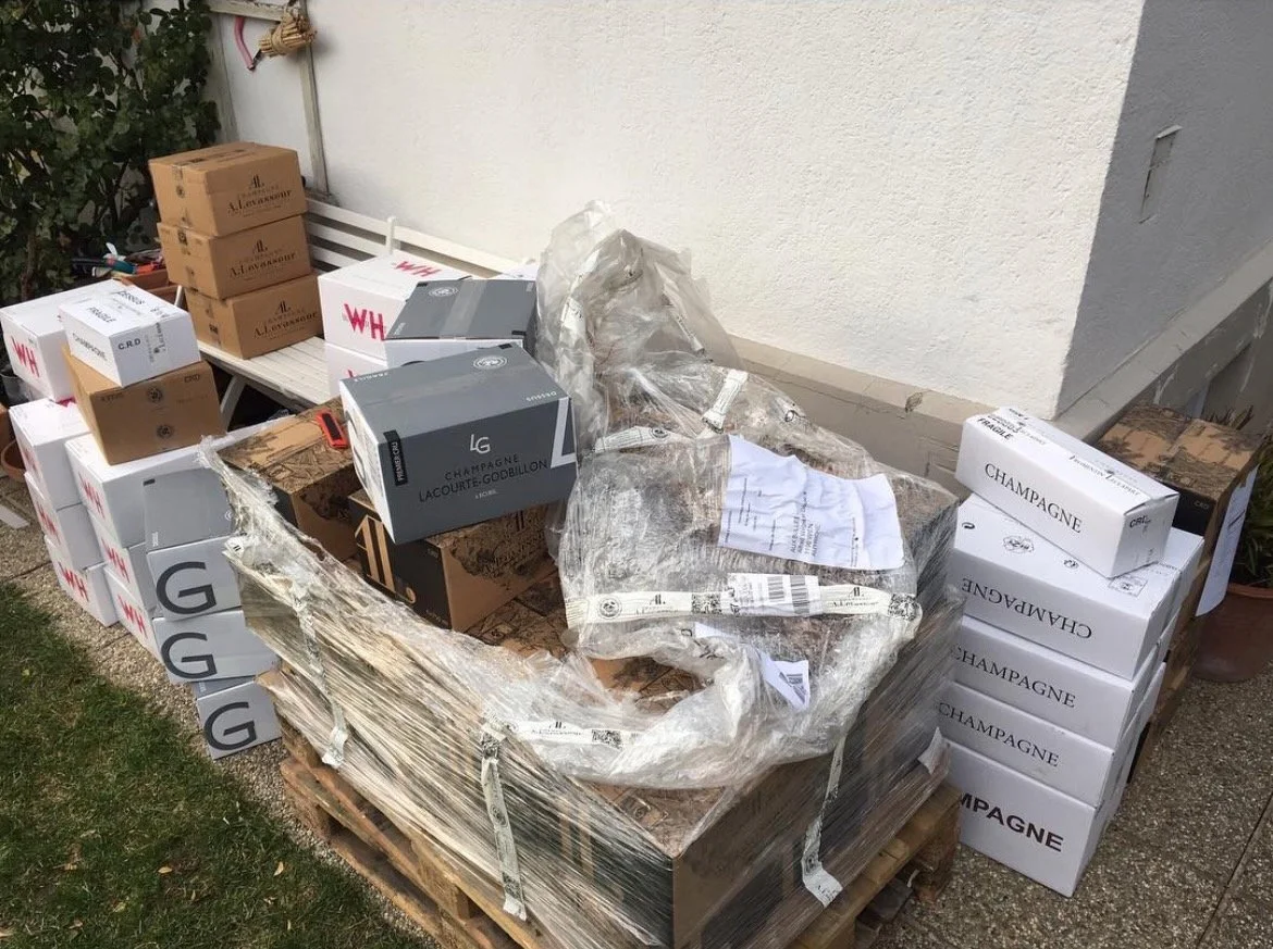 Unterschiedliche Champagerkartons an einer Hausmauer