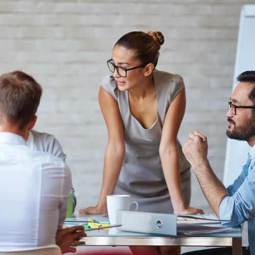 Photo Description: Several people are having a business meeting while sitting around a table.