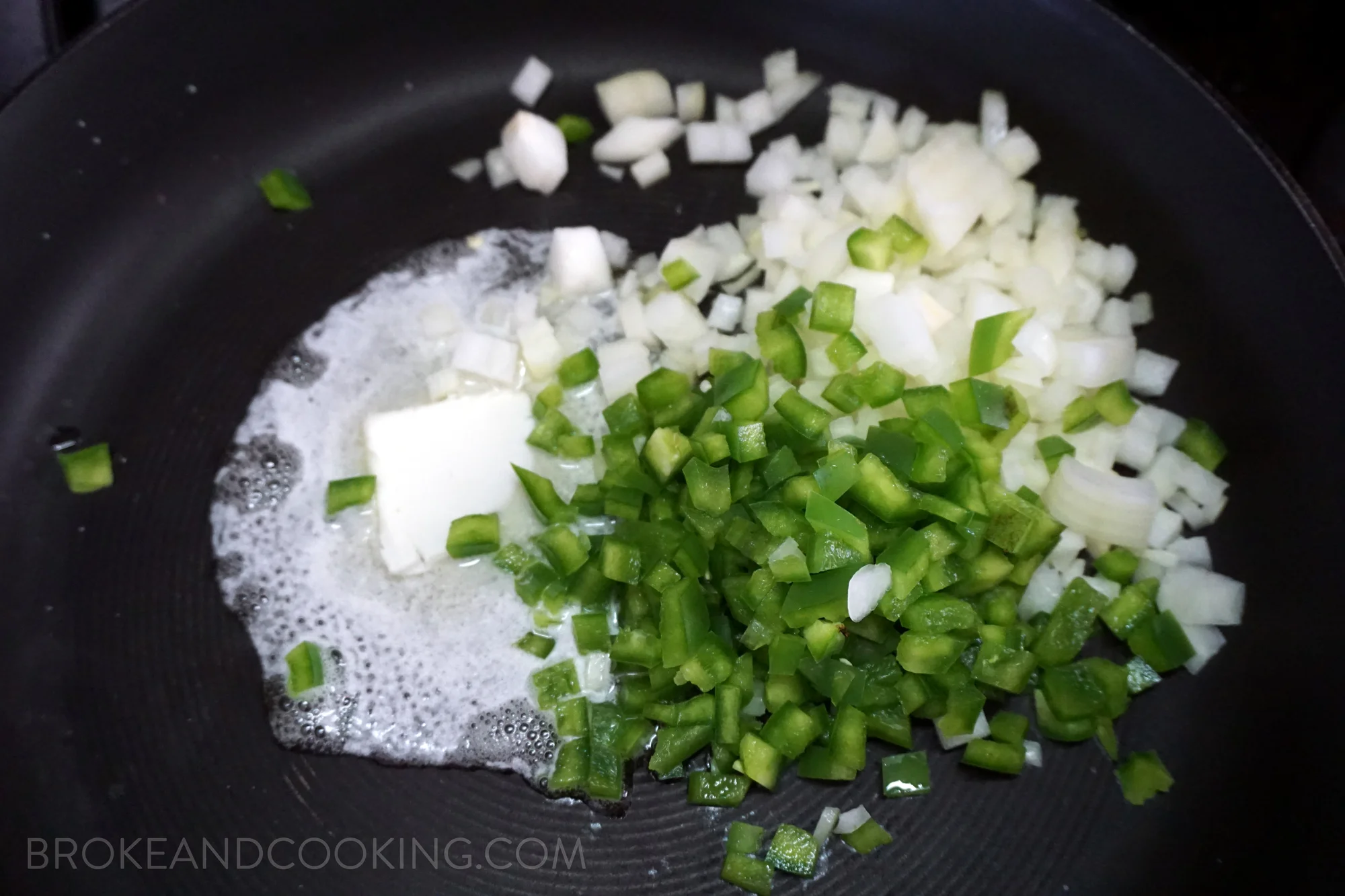 Now for the shrimp! Heat a large skillet over medium heat. Melt 2 tbsp butter and sauté the onions, minced garlic, and green bell pepper. Season with salt and pepper.
