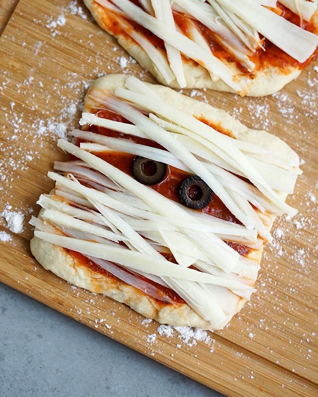 SpoOoky! Everyone loves a DIY Pizza Night :) Making Mini Mummy Pizzas is super simple with @traderjoes Pizza Dough. Actually, you can get all the ingredients for this recipe at TJ&rsquo;s and keep it under $10! This is the perfect holiday activity to
