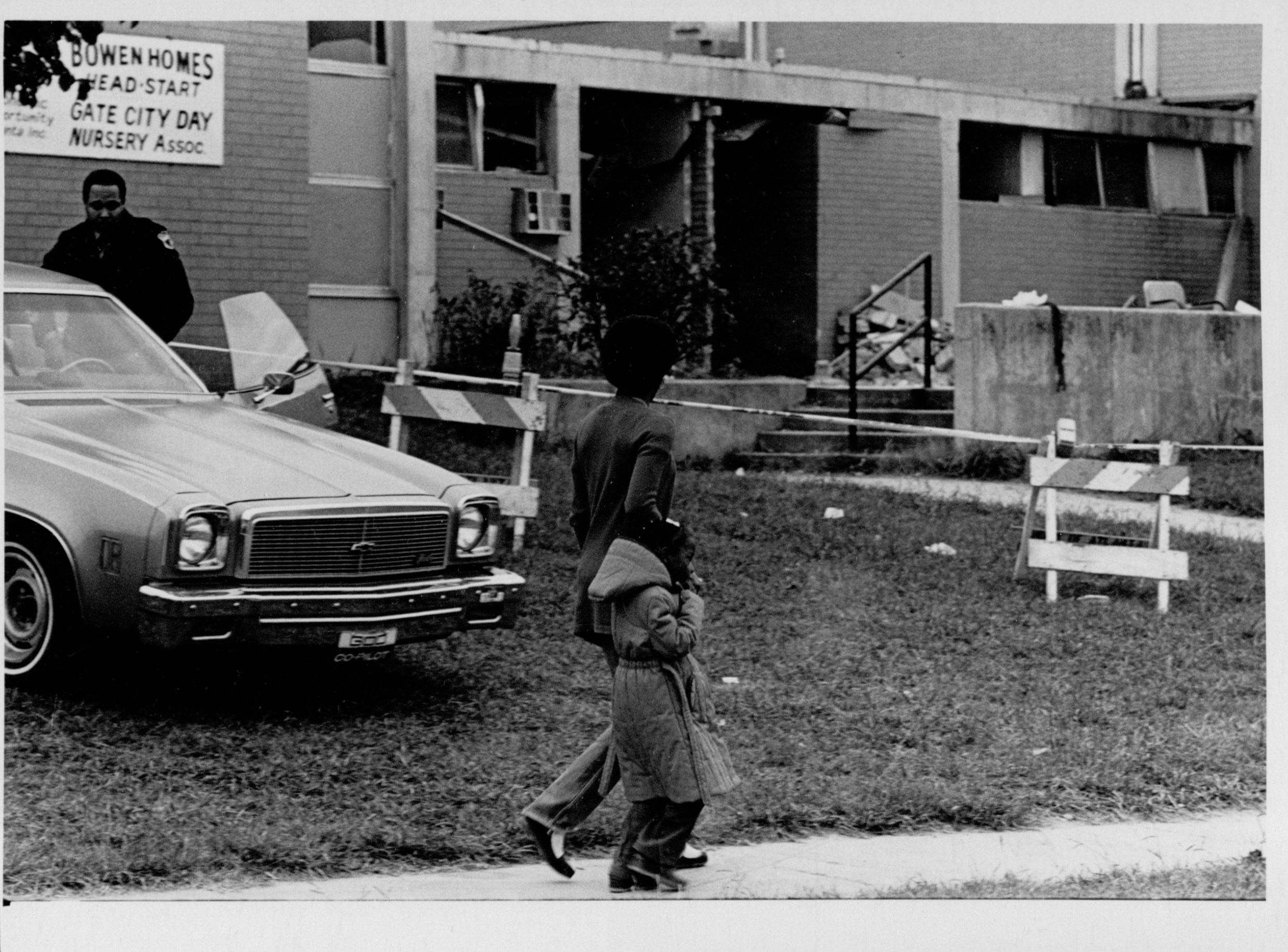 Tina and Lanecia walk past security guard at the blast site. Photograph by Steve Helber (1980) Atlanta Journal-Constitution Photographic Archives. Special Collections and Archives, Georgia State University Library.